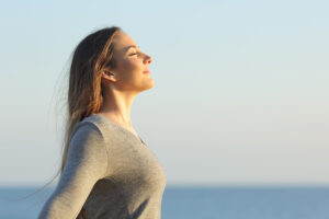 Une femme respire l'air frais au bord de la mer