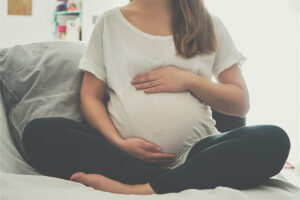 Femme enceinte assise touchant son ventre